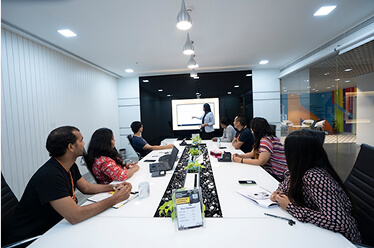 thumbnail-agencies people in a meeting room looking at a tv monitor